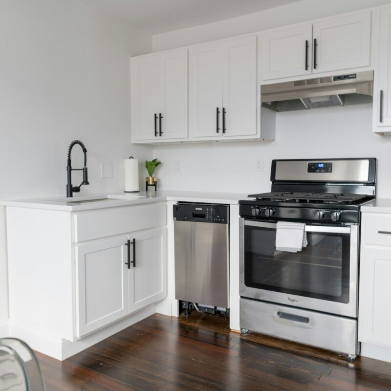 white wooden kitchen cabinet and white microwave oven